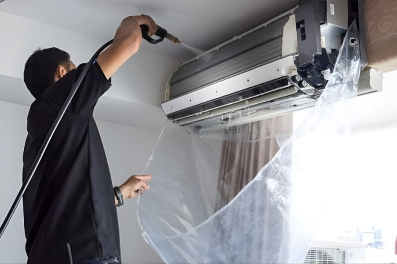 Kỹ thuật viên vệ sinh máy lạnh treo tường tại nhà trong dịch vụ sửa chữa điện lạnh Quận 10